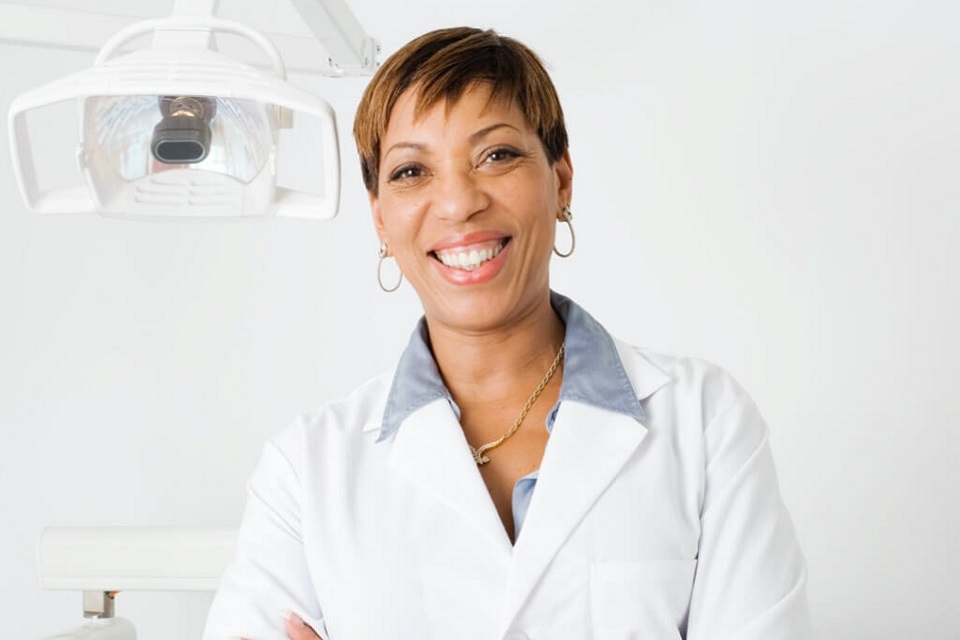 Female dentist in white coat smiling