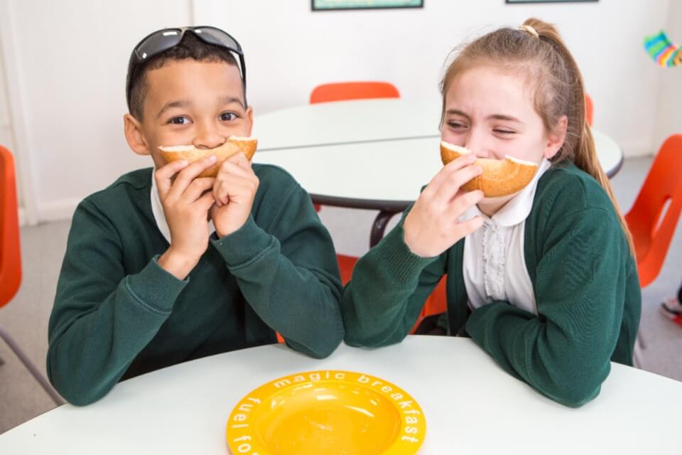 Two school children having breakfast