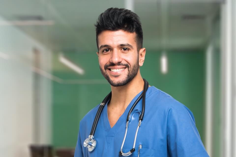 Male healthcare worker standing in hospital corridor