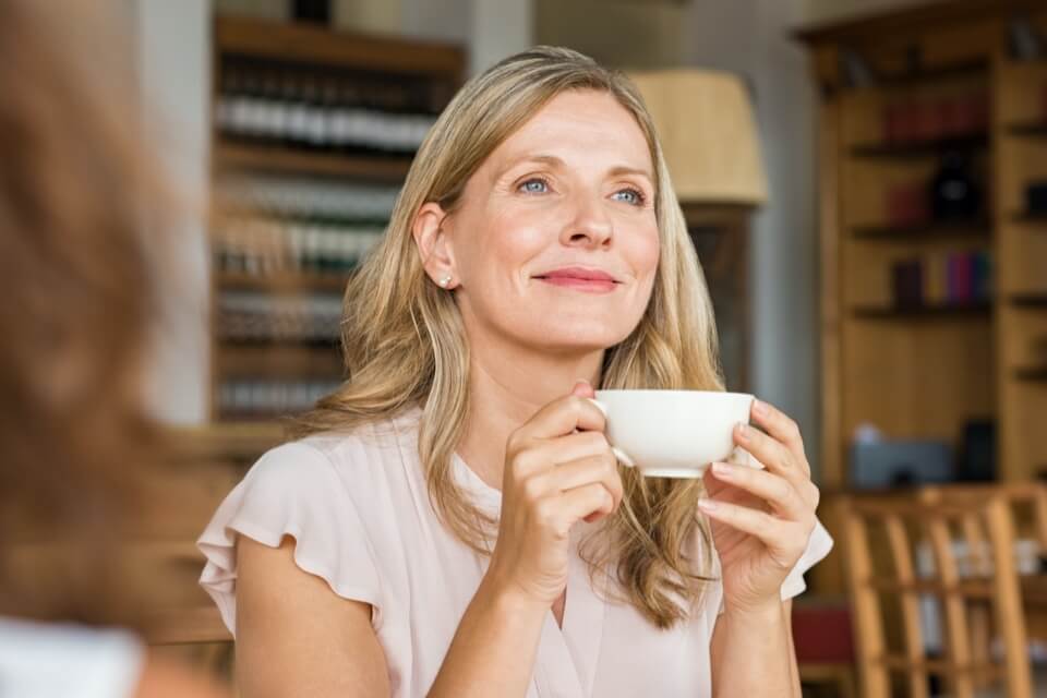 mature lady in cafe holding a mug