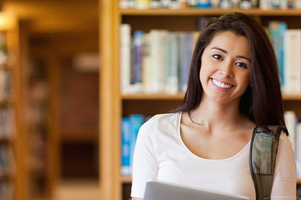 Female medical student smiling in library