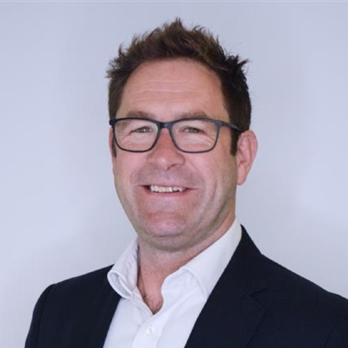 Young female dentist in scrubs smiling