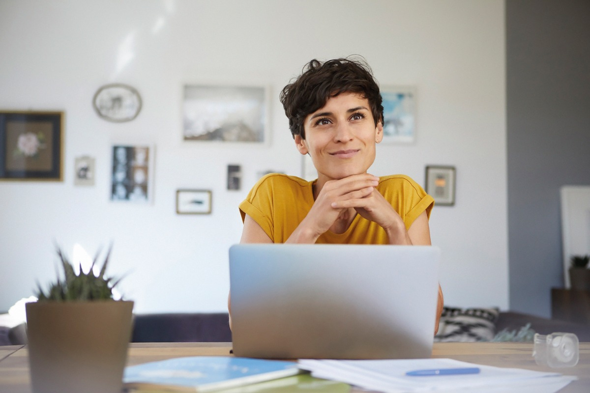 billboard-female-sitting-at-breakfast-bar Smiling woman sitting at breakfast bar with laptop