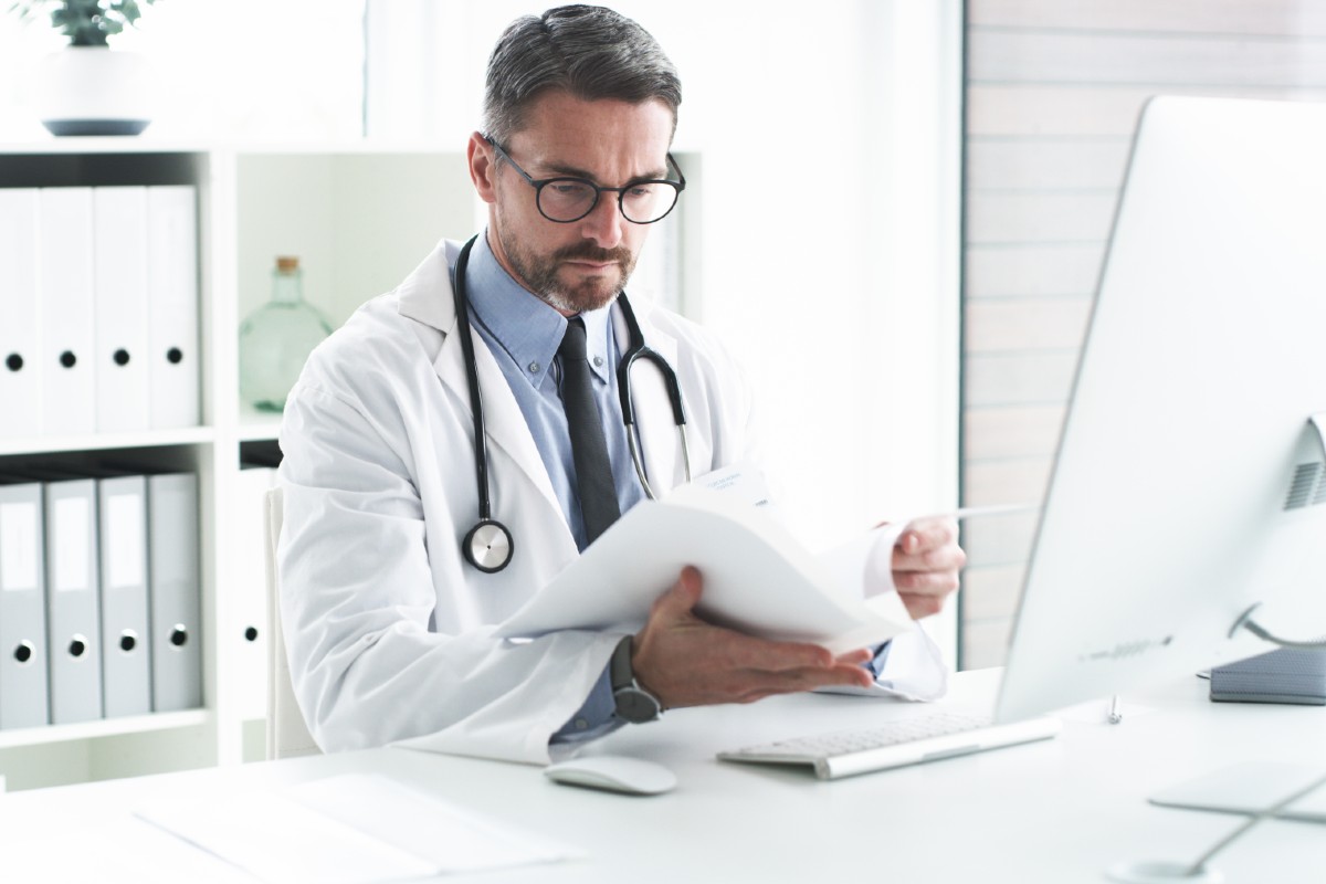 billboard-male-doctor-in-office-looking-at-papers Male doctor in office looking at papers