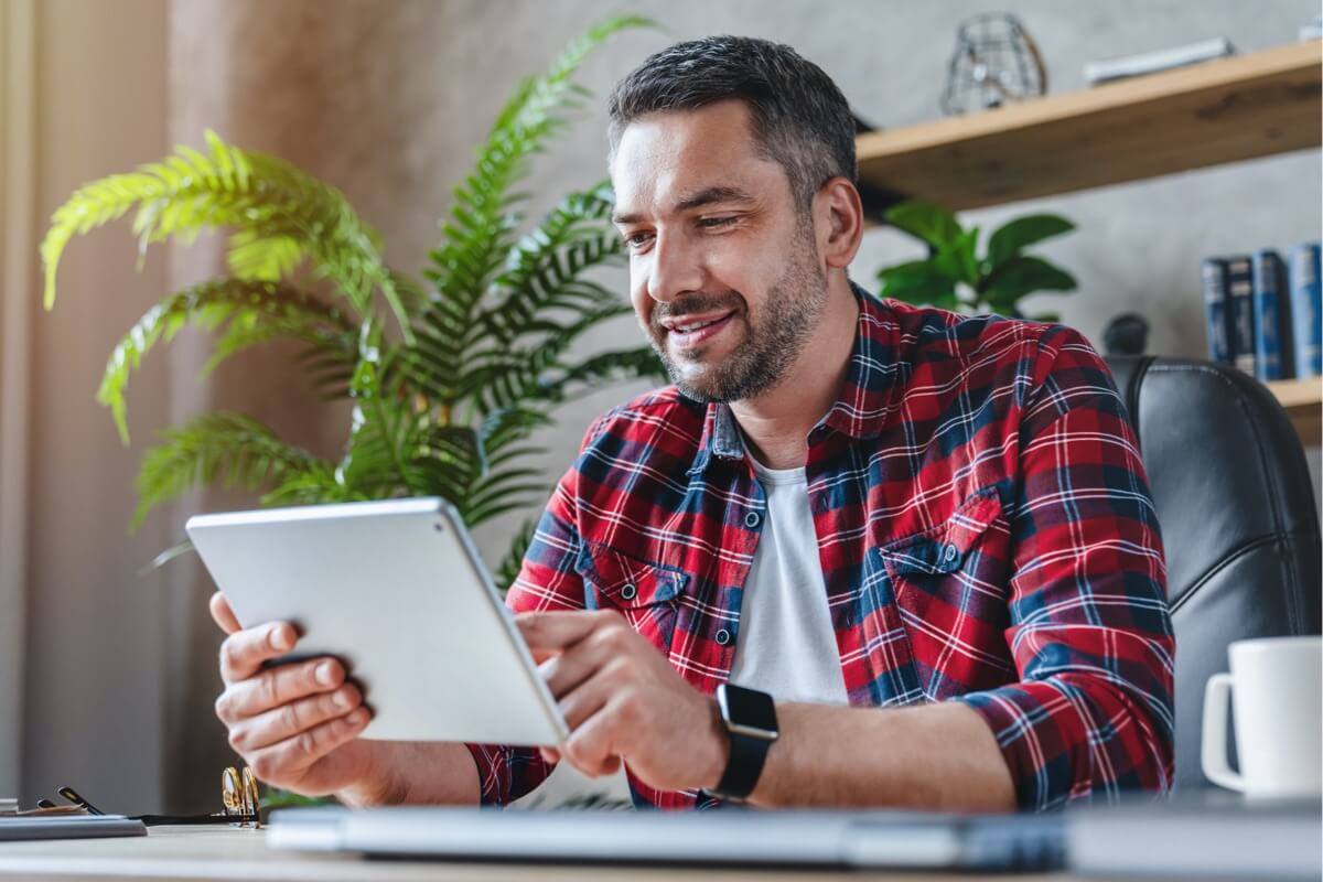 billboard-man-in-checked-shirt-looking-at-tablet Man in checked shirt looking at tablet