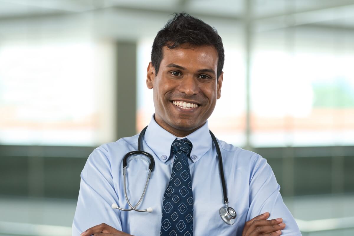 Smiling male doctor wearing stethoscope Smiling male doctor wearing stethoscope