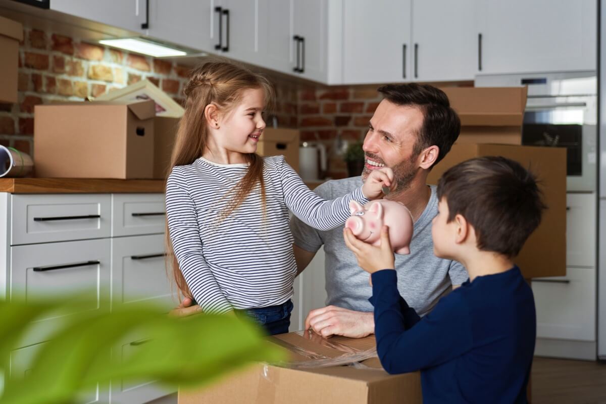 Father with young children moving boxes in home Father with young children moving boxes in home