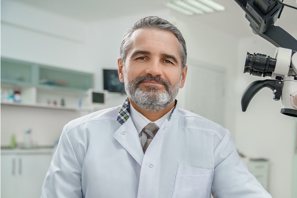 Mature male dentist wearing tie sitting on chair Mature male dentist wearing tie sitting on chair