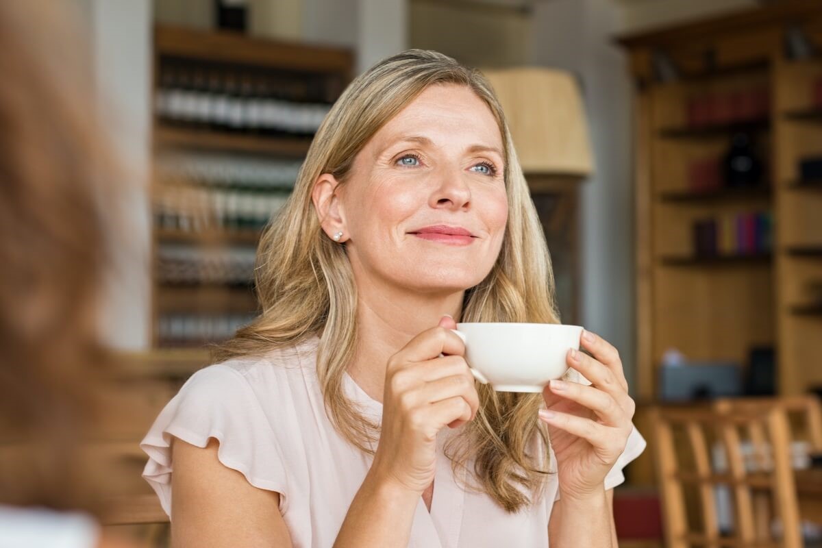 Mature woman holding mug smiling Mature woman holding mug smiling