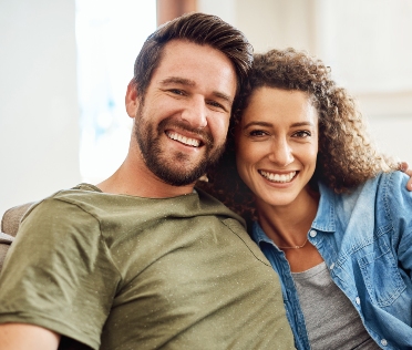 Young couple on sofa smiling