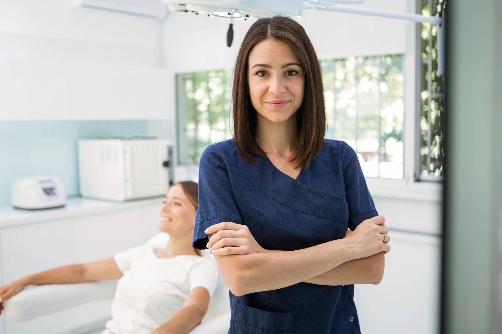 Young female dentist wearing navy blue scrubs