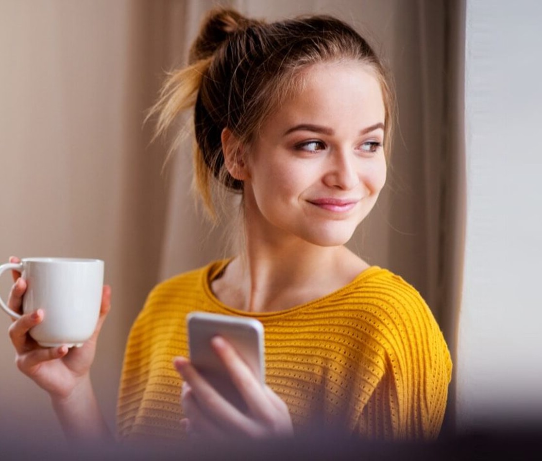 Young female smiling and holding mug Young female smiling and holding mug