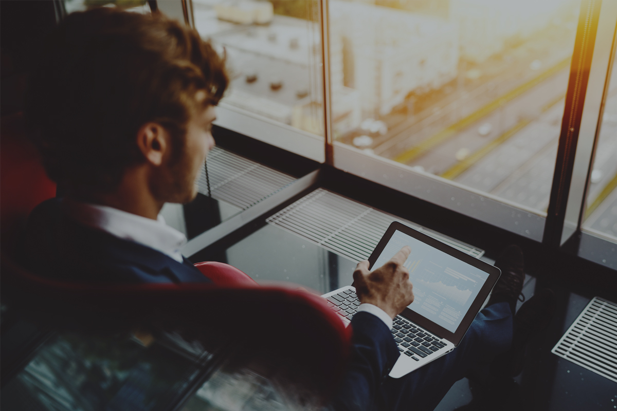 billboard-webinars-male Man in high-rise building using laptop
