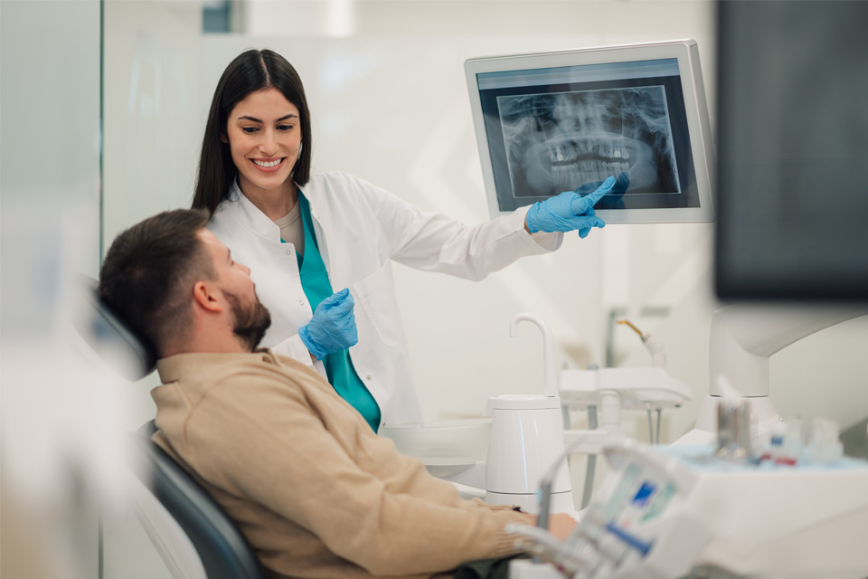 Female dentist showing x-ray to patient
