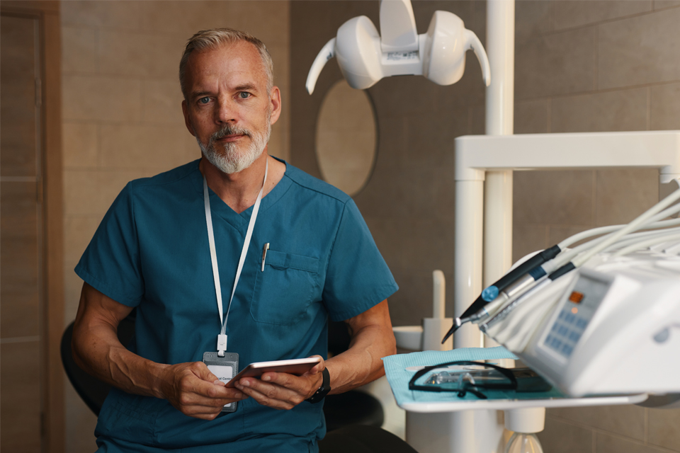 Mature male dentist in scrubs