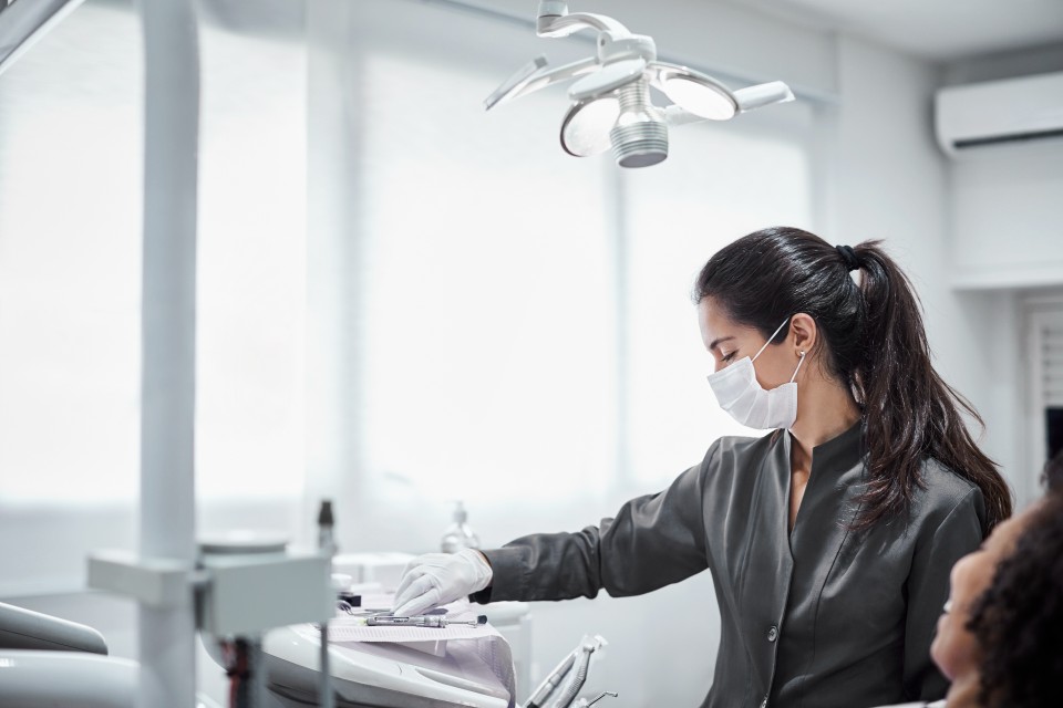 Female dentist reaching for tools