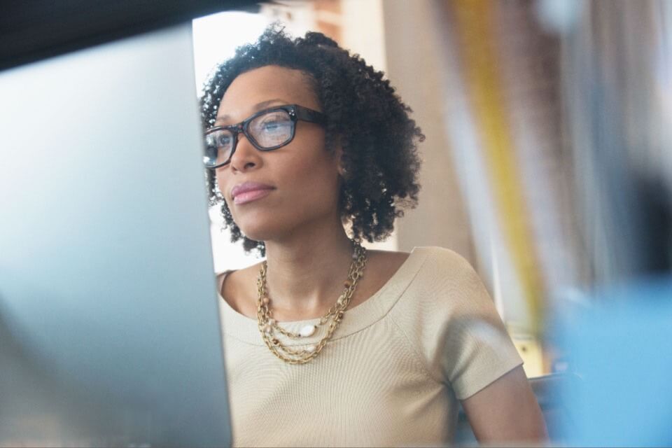 Professional woman looking at computer screen wearing glasses