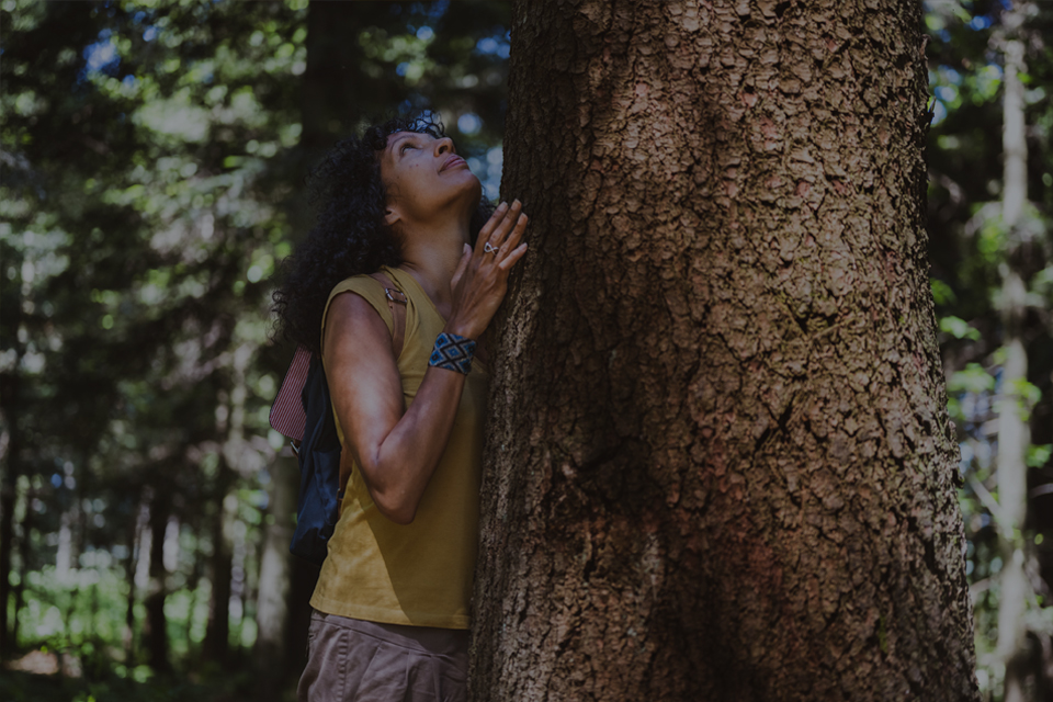 Mature woman stood with tree