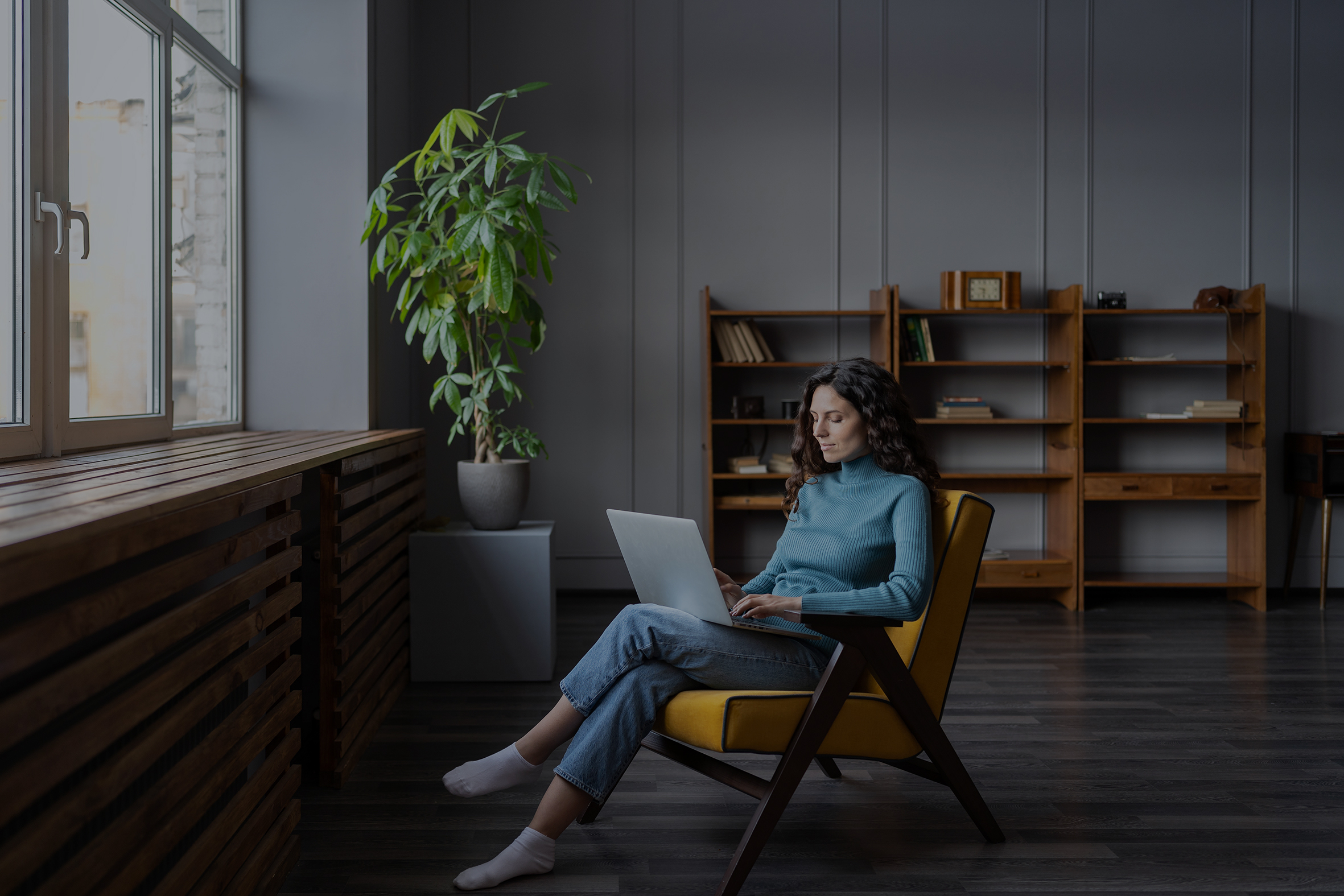 Woman sat in chair on a laptop