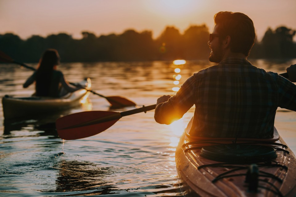 Couple in canoe boat on water during sunset