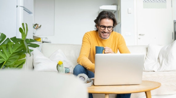 Man at home on sofa with laptop