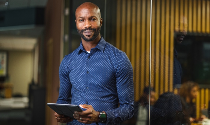 Professional man in office holding tablet