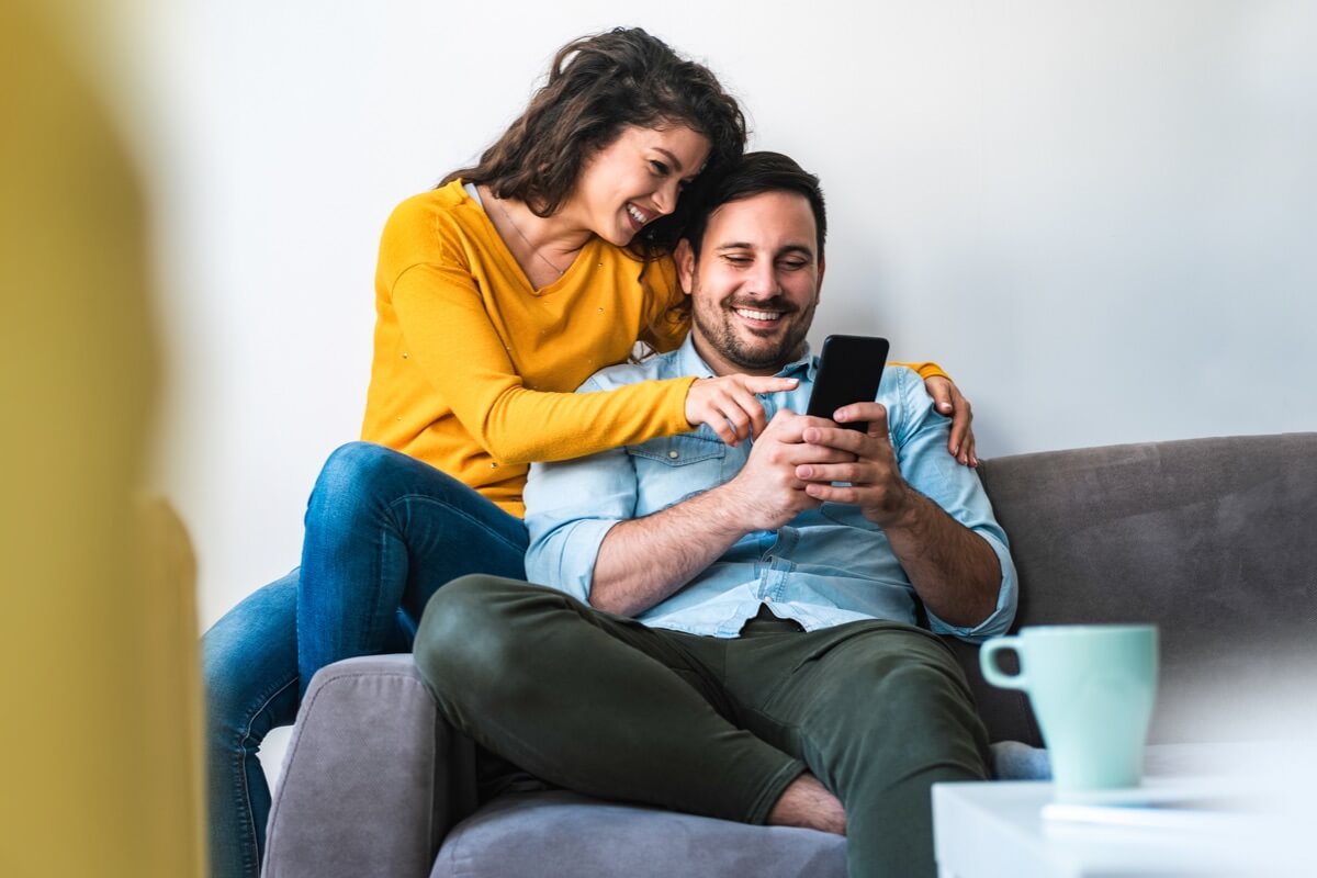 Couple on sofa looking at phone
