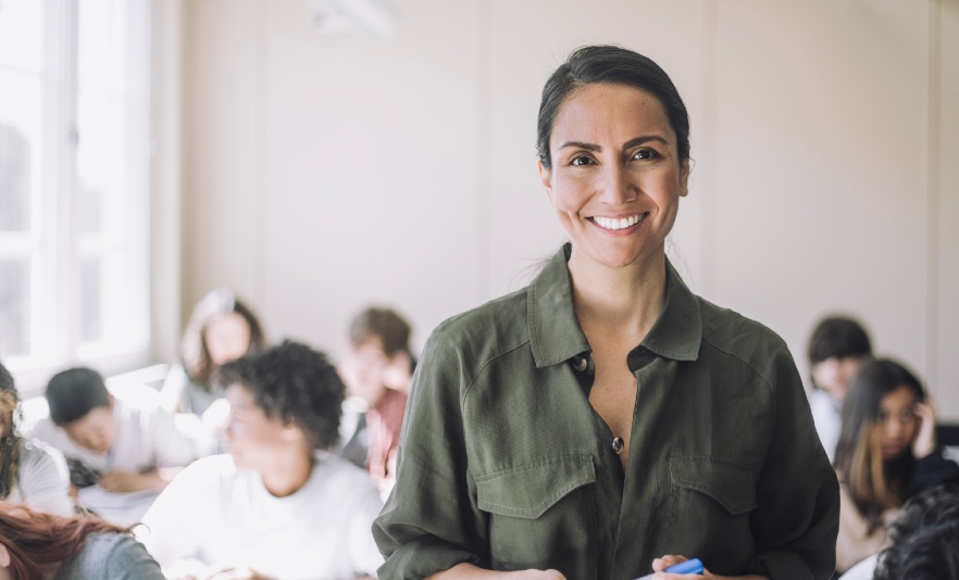 Female teacher standing in classroom full of students