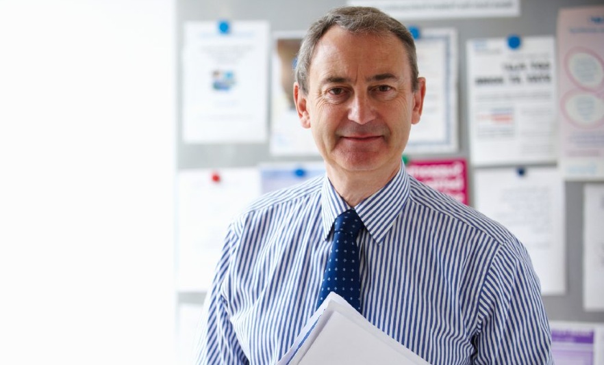 Male gp standing in front of notice board