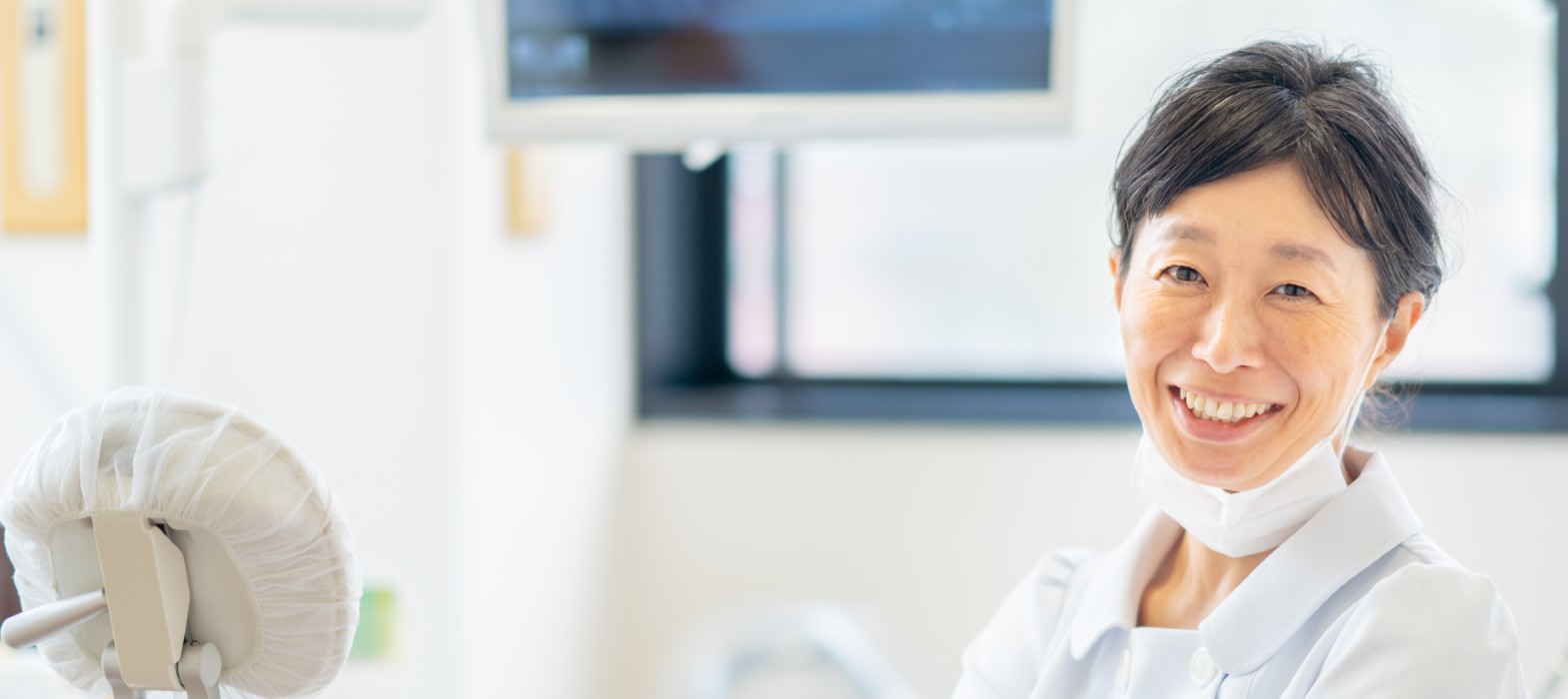Female dentist smiling with mask pulled down