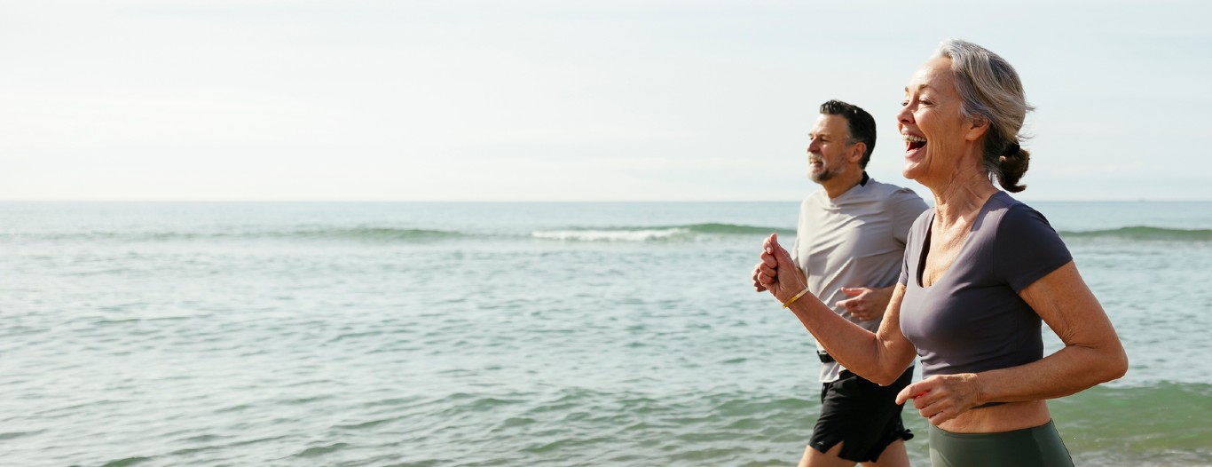 Mature couple running on beach