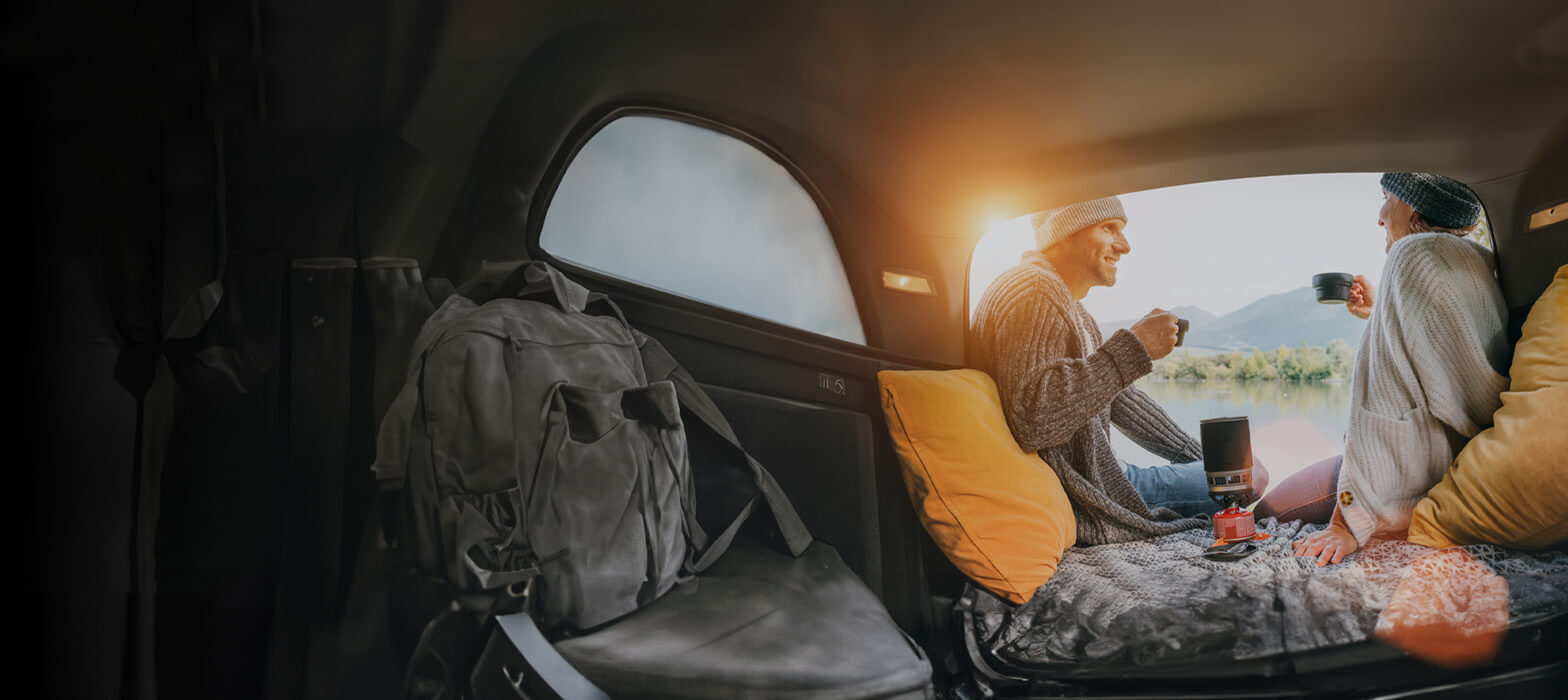 Couple in camper van drinking from mugs