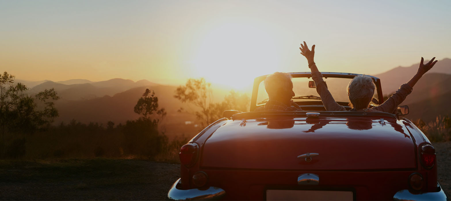 Mature couple in car in front of sunset