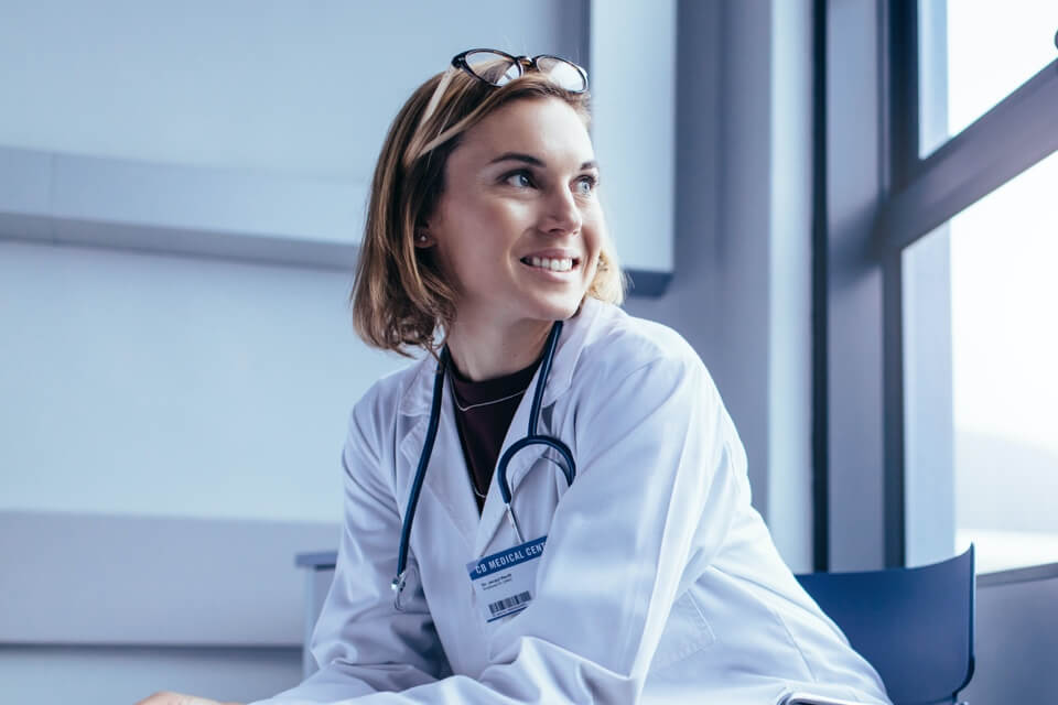 blog-female-doctor-sitting-on-chair-looking-out-window Female doctor sitting on a chair looking out the window