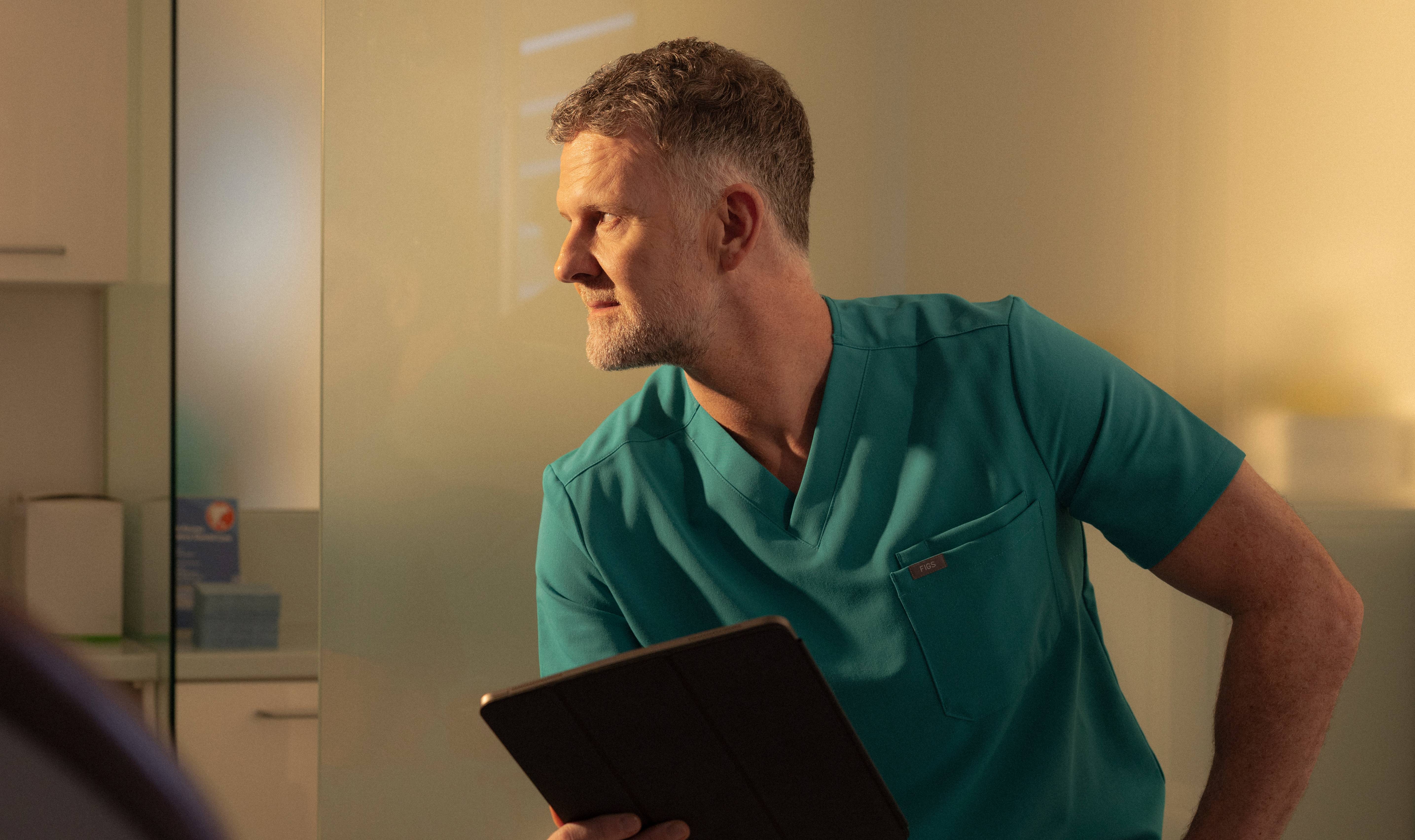 Male dentist holding clipboard