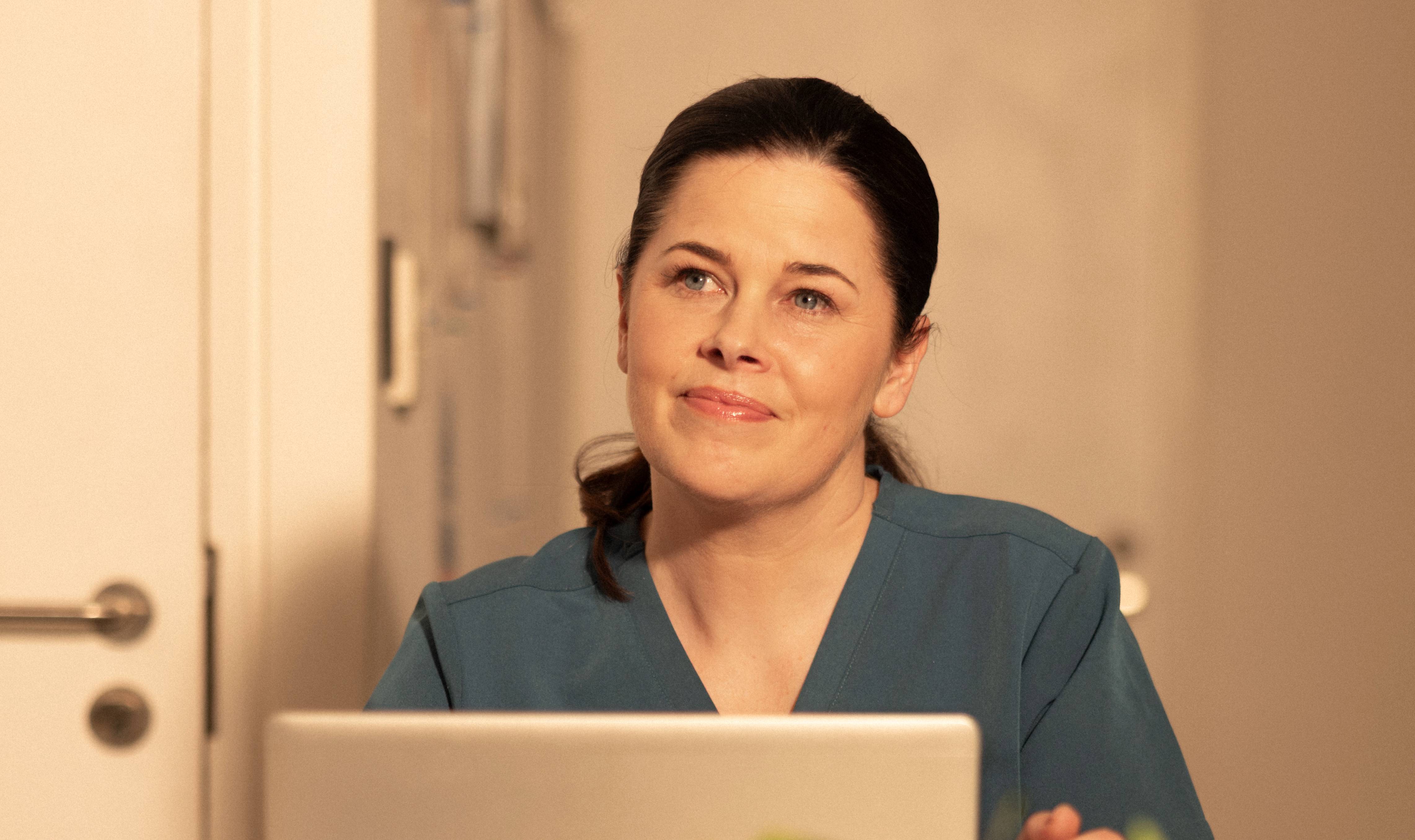 Female dentist looking over the top of her laptop