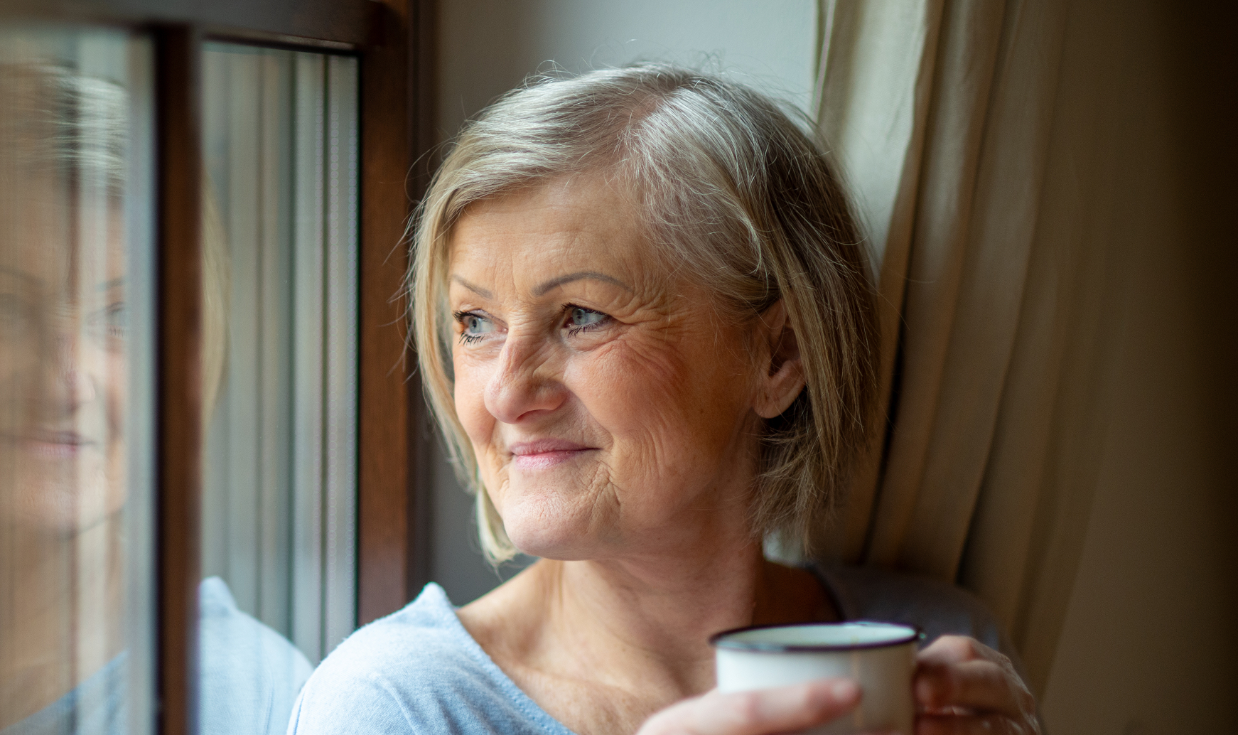 Mature woman stares out of window