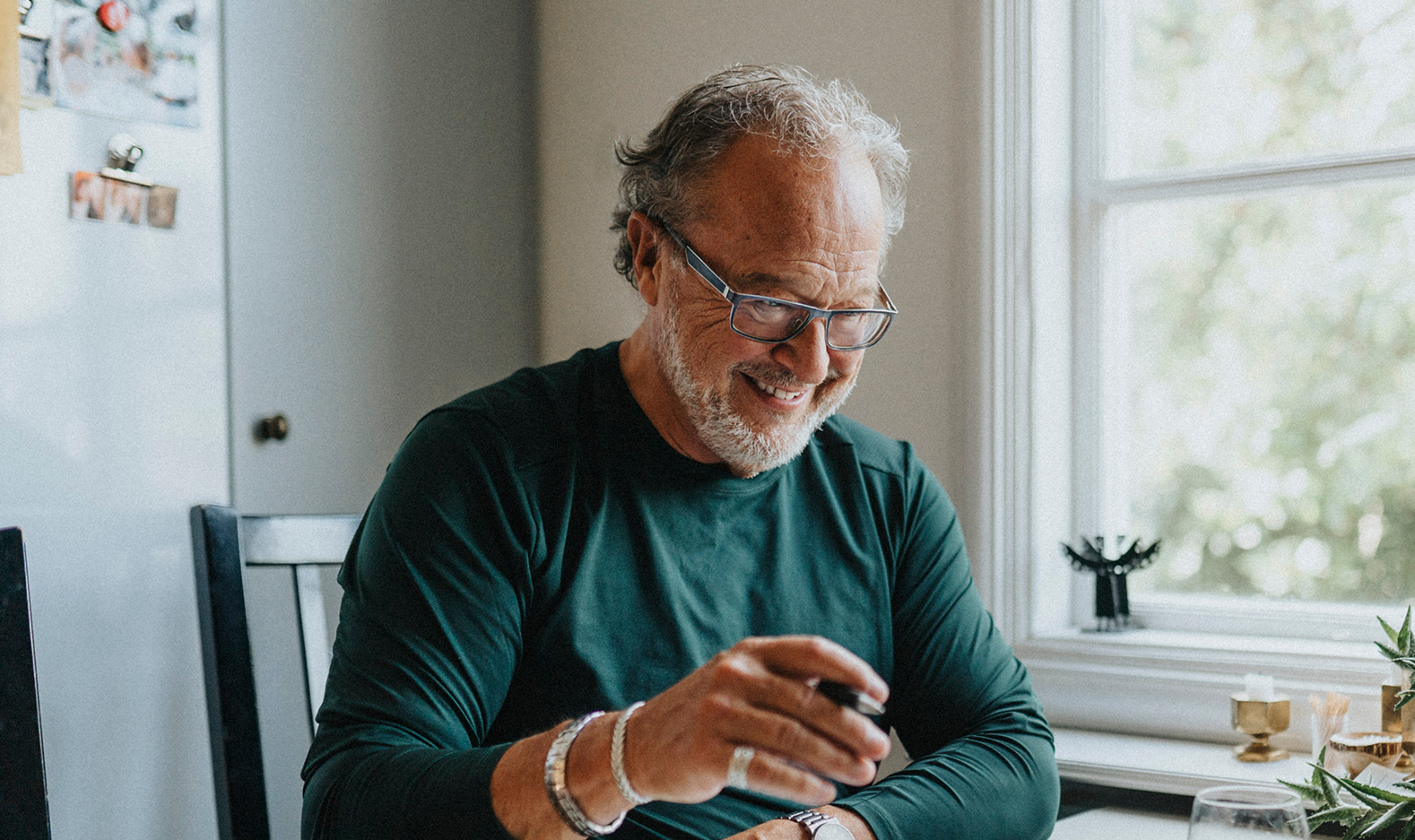 Mature man holding pen whilst smiling
